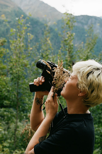 Frau in der Natur mit analoger Kamera